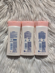 Three baby lotion bottles with pink caps on a fluffy white surface