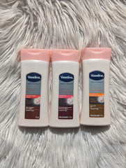Three Vaseline body lotion bottles on a fluffy white surface